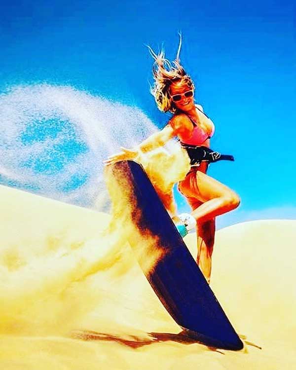 Tourist Girl doing Sandboarding in Dubai Desert Safari Tour