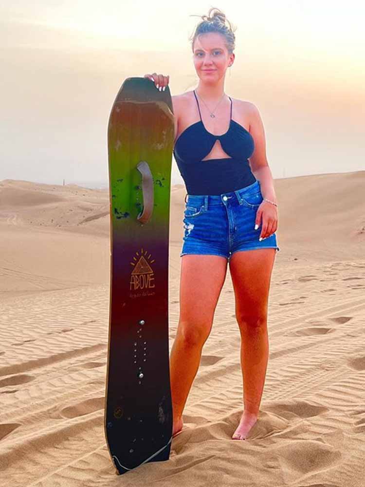 Tourist Girl Ready for Sandboarding in Dubai Desert