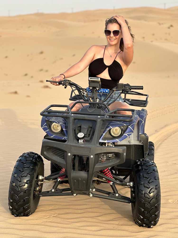 Tourist Girl Riding Quad Bike in Dubai Desert