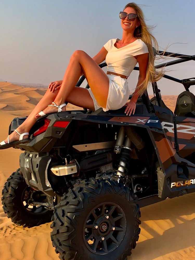 Tourist Girl Sitting on Dune Buggy in Dubai Desert