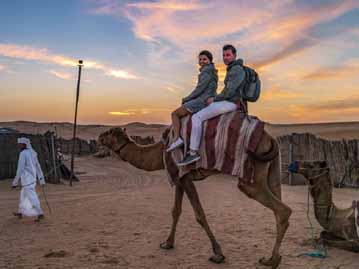 Couple Riding Camel together during Evening Safari in Dubai