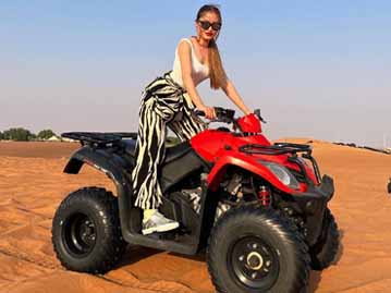 Tourist Girl Riding Quad Bike in Dubai Desert