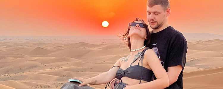 Man Holding His Girlfriend during Evening Desert Safari Tour at Sunset - Secrets of Dubai Desert Safari