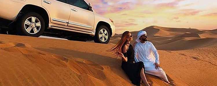Young Couple in Dubai Desert with Land Cruiser in the Back - Safe Driver Dubai