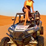 Tourist Girl Sitting on top pf Dune Buggy for Photoshot