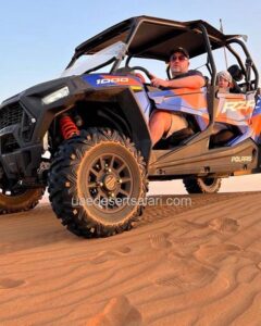 Tourist Man Riding 4-Seater Dune Buggy with his Baby in the back during Desert Safari