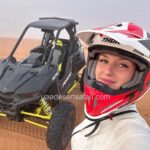 Tourist Girl Wearing Helmet standing in front of Dune Buggy